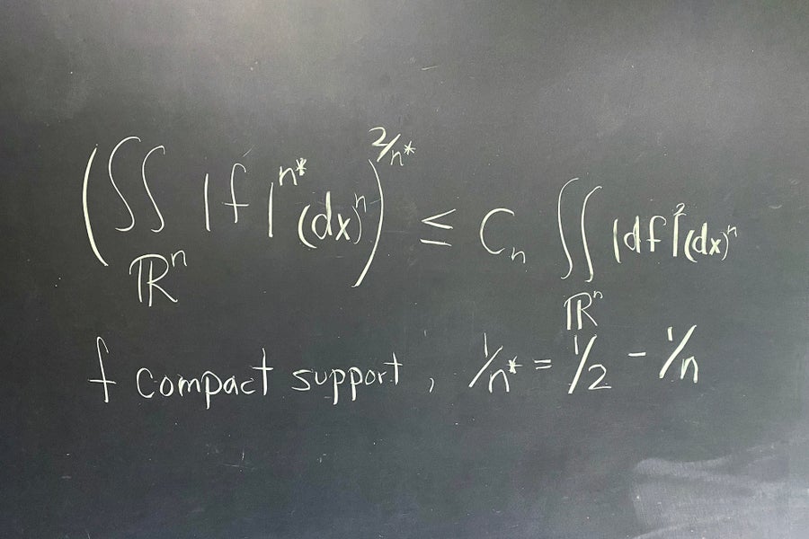 Math equation written in white on a black board.