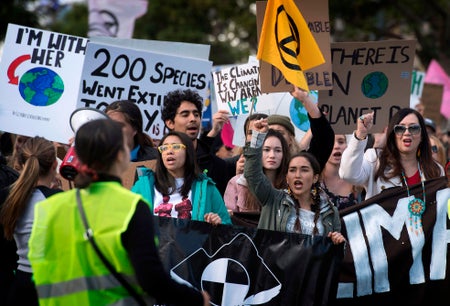 A group of people holding signs with climate action messages.