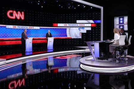 CNN Studio with read and blue striped background and Trump/Biden on the left with both ancors on elevated platform.